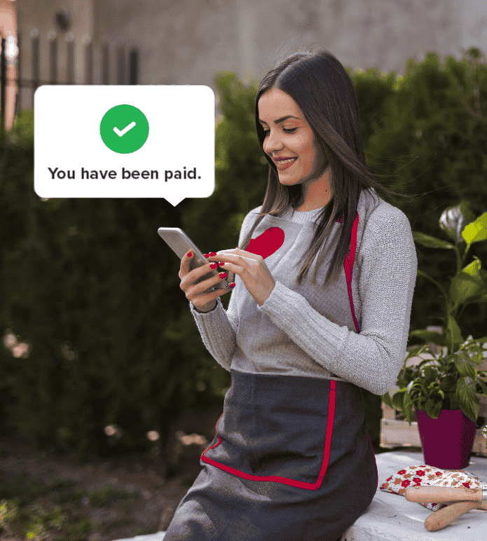 Employee smiling at phone after receiving payment notification